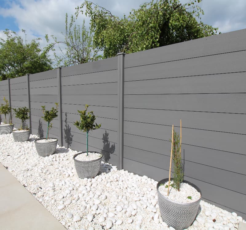 modern composite fencing in grey with plant pots going down it